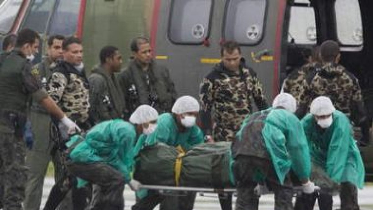 Militares descargan el segundo grupo de ocho cadáveres de las víctimas.