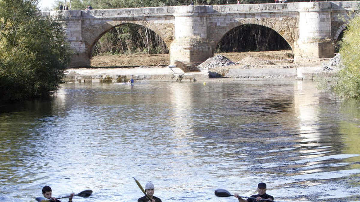 Los palistas leoneses entrenan sobre un río Bernesga que tienen que limpiar antes de comenzar cada sesión.