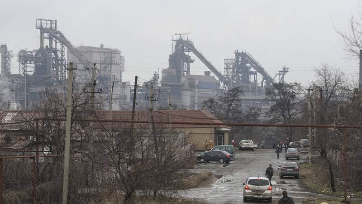 Varias personas mientras pasean cerca de la planta metalúrgica de Uzov.