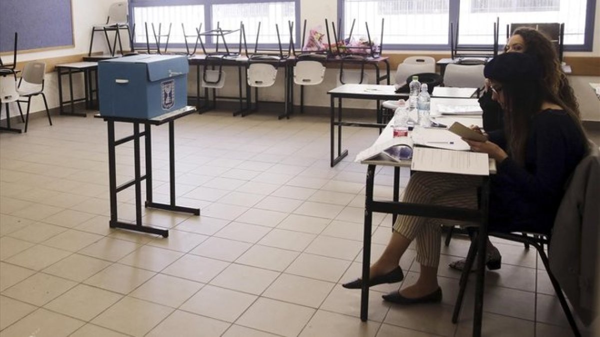 Miembros de una mesa electoral esperan la llegada de votantes en un colegio del este de Jerusalén.