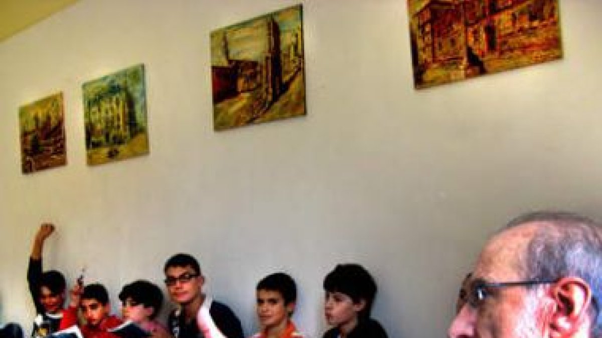 Santiago Omaña enseña su exposición a los escolares.