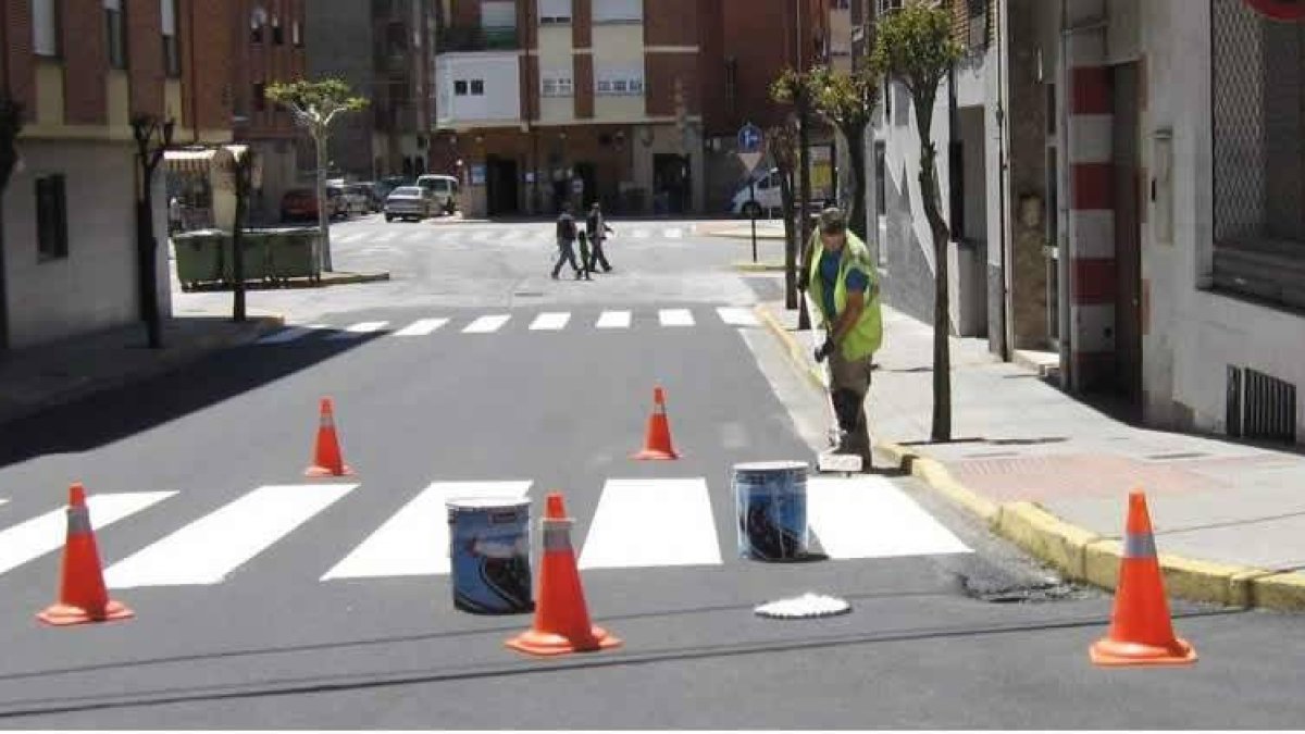En la imagen, un operario pintando uno de los pasos de peatones de la calle La Martina.