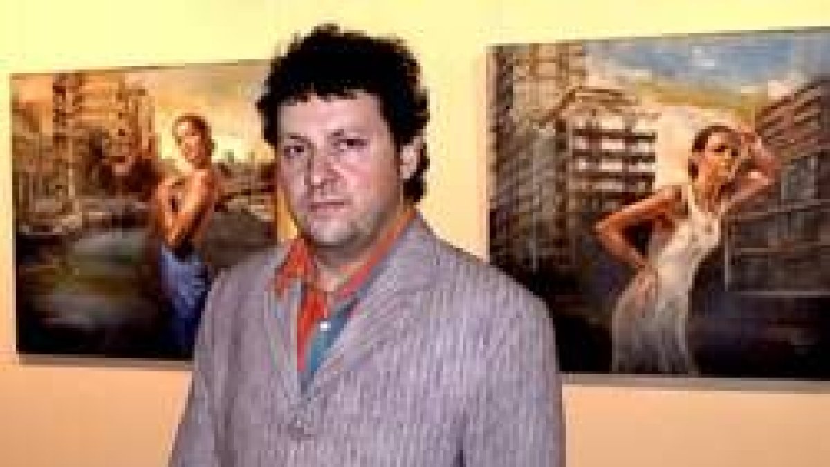 El artista Martin Riwnyj posa junto a dos de sus obras