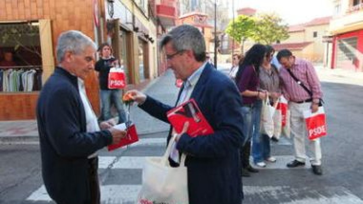 El candidato del PSOE regala una flor a un vecino.