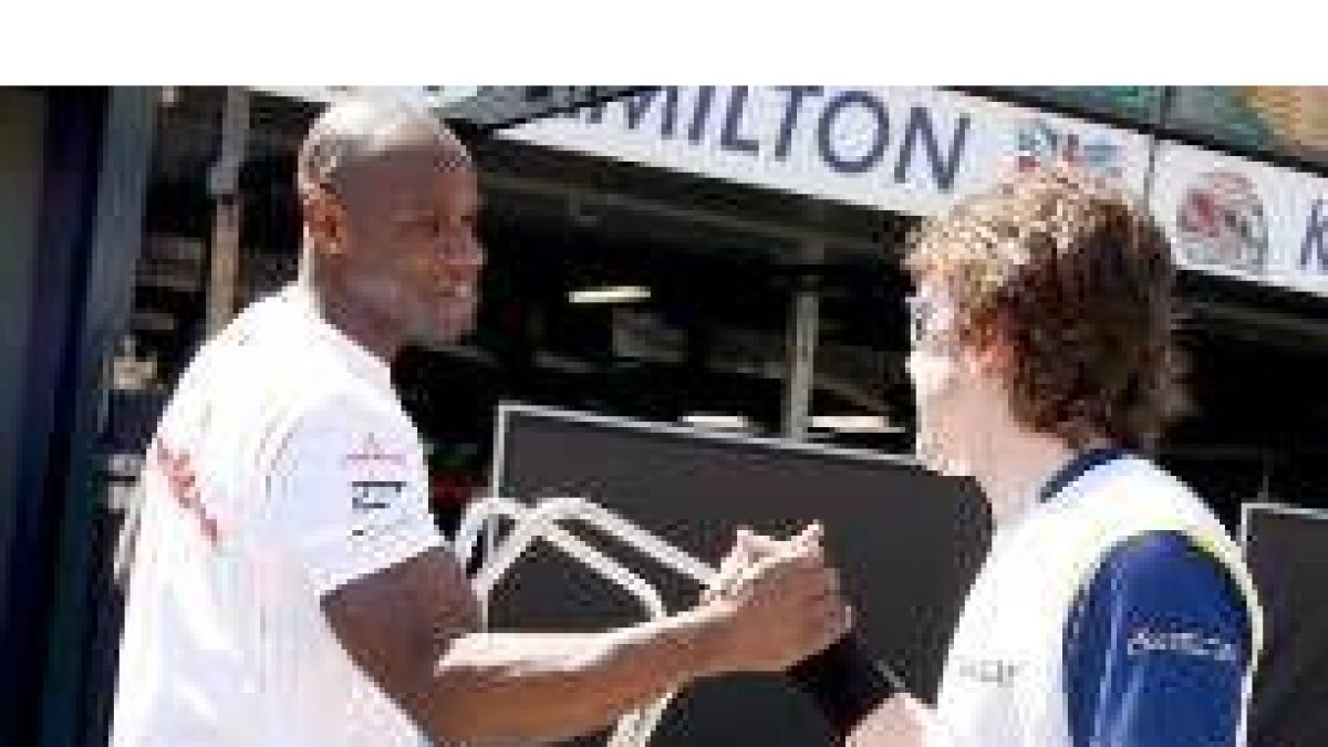 Alonso saluda a un mecánico de su anterior equipo, McLaren, en Melbourne