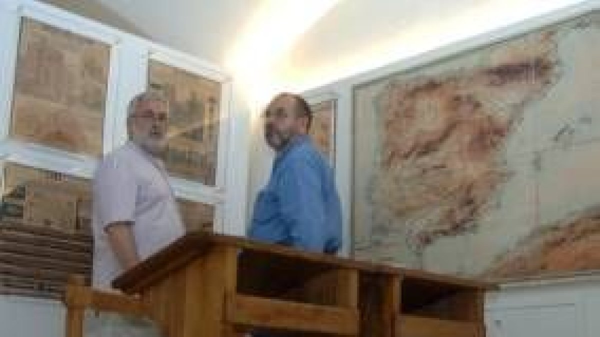 Dos visitantes contemplan material escolar en el Museo Sierra-Pambley