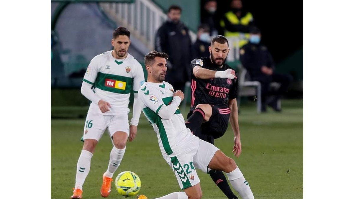 Benzemá, a la derecha, golpea el balón ante el defensa del Elche, Josema. RAMÓN