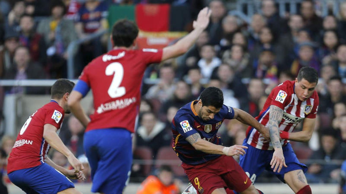 Luis Suárez, rodeado de jugadores del Atlético, durante el encuentro de Liga. ALEJANDRO GARCÍA