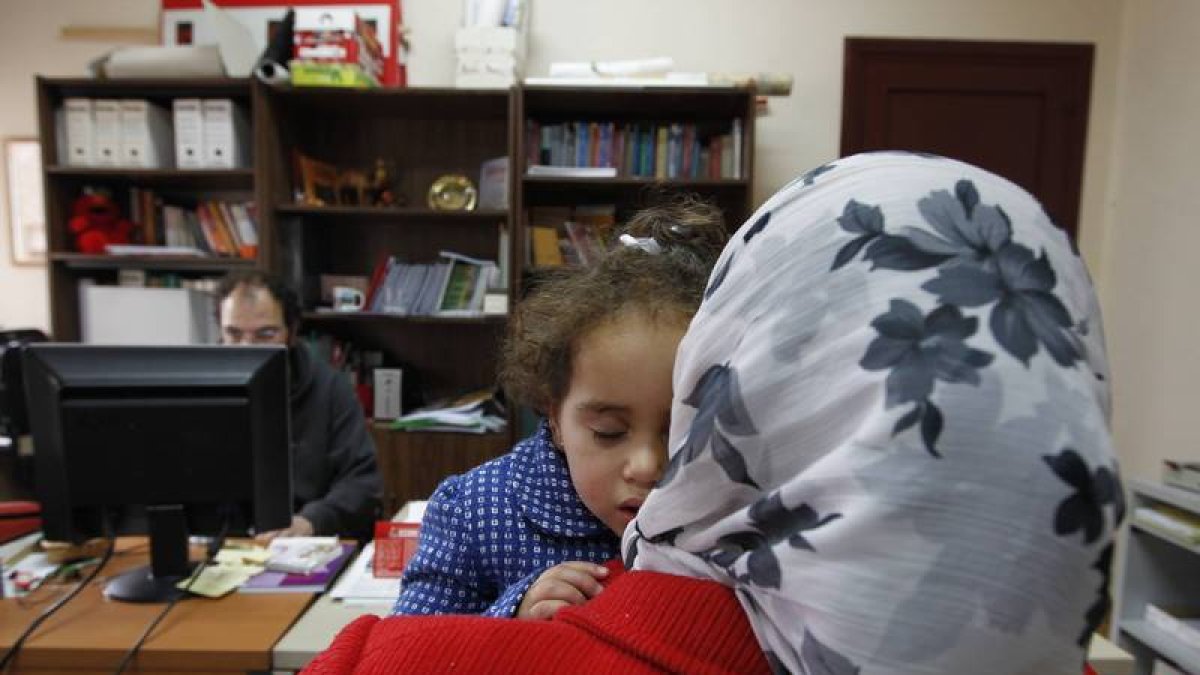 Una mujer de origen marroquí con su hija en un centro de información en León