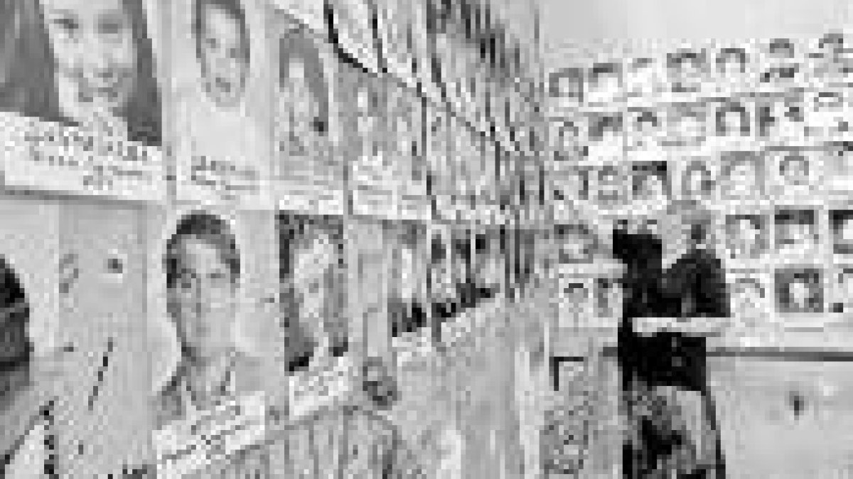 Una mujer mira las fotos de las víctimas de la masacre expuestas en un muro de la escuela de Beslán
