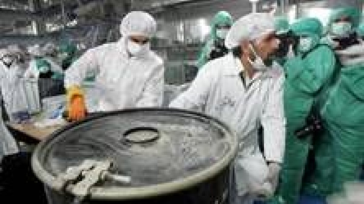 Científicos iraníes transportan  un bidón de uranio radiactivo en la central de Ispahán