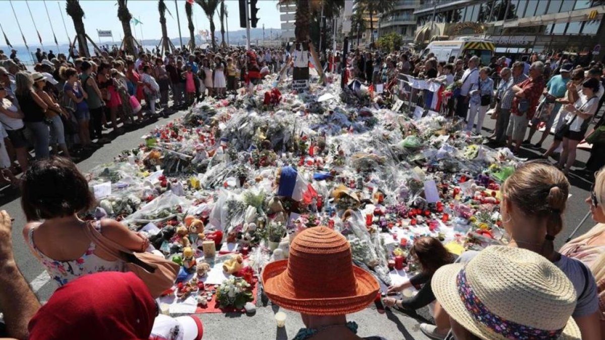 Centenares de personas se reúnen alrededor de las flores situadas en el Paseo de los Ingleses para homenajear a las víctimas