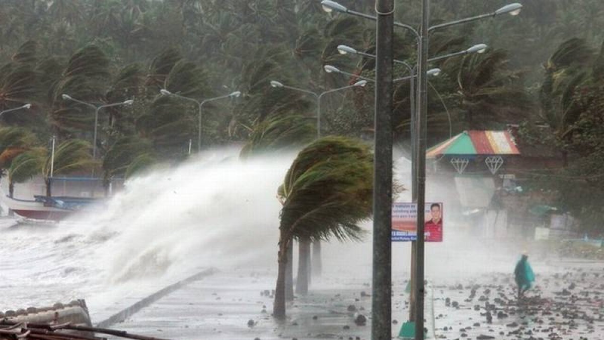 Un vecino pasa junto a enormes olas levantadas por el supertifón Haiyan, este viernes en Legazpi, al sur de Manila.
