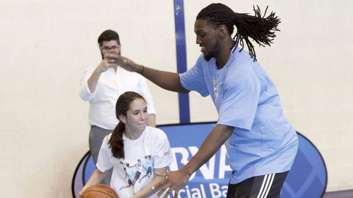 Kenneth Faried compartió la magia del baloncesto con decenas de jóvenes jugadores leoneses en el Pabellón Margarita Ramos. En la imagen, defiende el ataque de una niña.