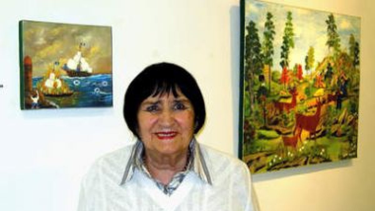 La artista asturiana ante dos de las obras expuestas en Ármaga