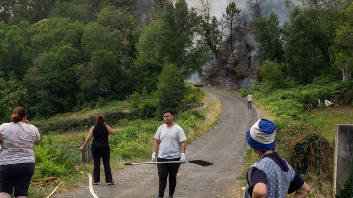 Los vecinos combaten el fuego en la aldea de Froxan, O Courel, en Lugo. EFE/ELISEO TRIGO