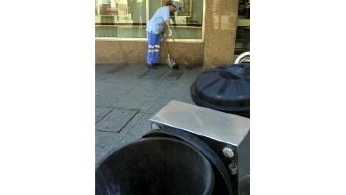 Una operaria de la limpieza realiza su trabajo en una calle de León