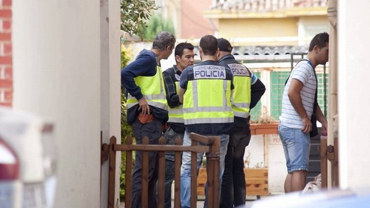 Agentes de la Policía Nacional, durante el registro que han realizado en la vivienda donde ha sido detenido hoy el presunto pederasta del barrio madrileño de Ciudad Lineal.