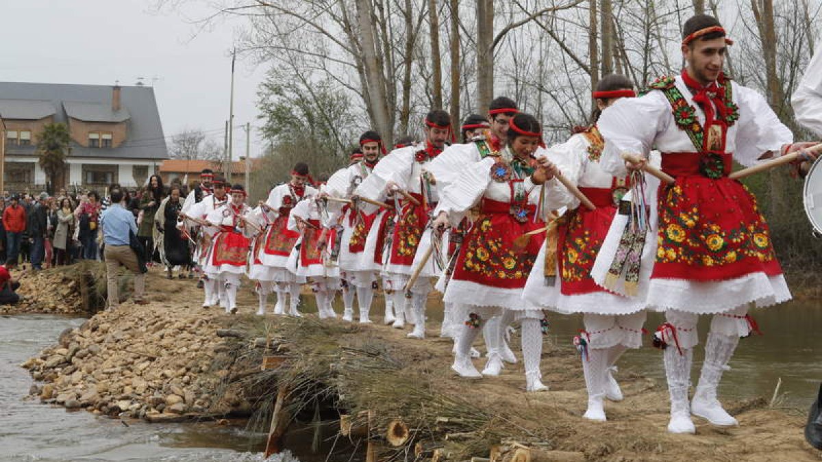 Los danzantes, este año por partida doble, cruzan el Eria acompañando la romería del patrón hasta el otro lado del río. RAMIRO