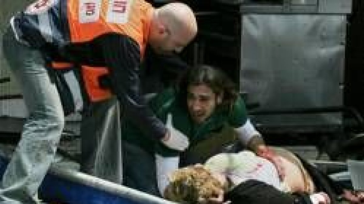 Un hombre trata de hacer reaccionar a una de las víctimas del atentado en la capital israelí