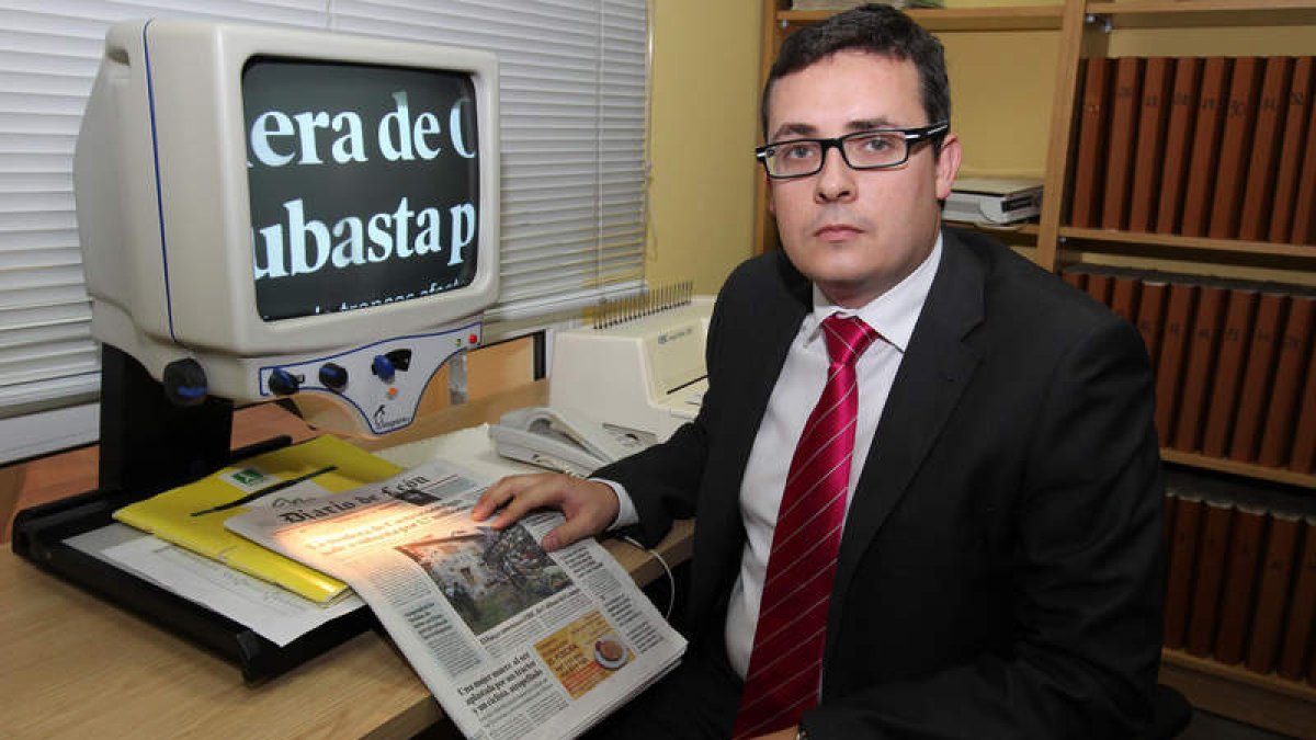 El director de la Once en León, Óscar Pérez López, utiliza una lupa especial para leer el DIARIO DE LEÓN.
