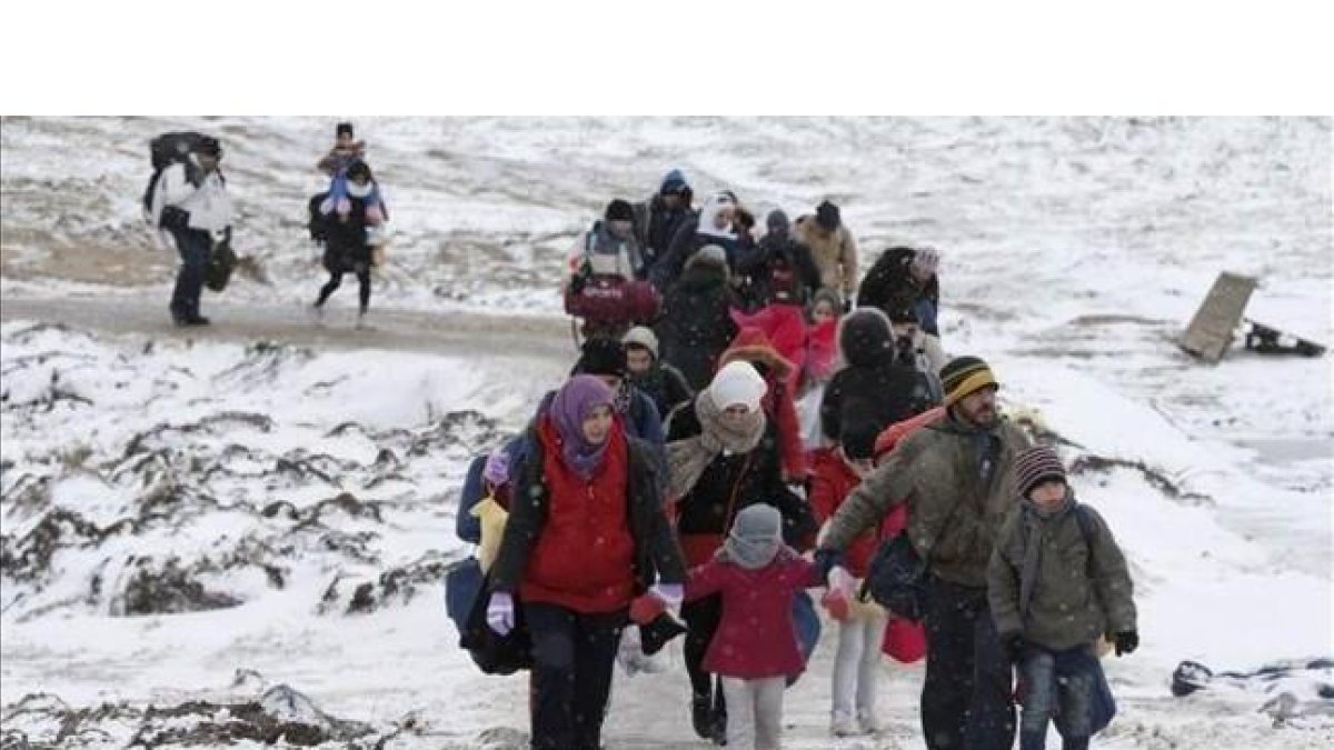 Familias de refugiados tras cruzar la frontera de Macedonia, este lunes.