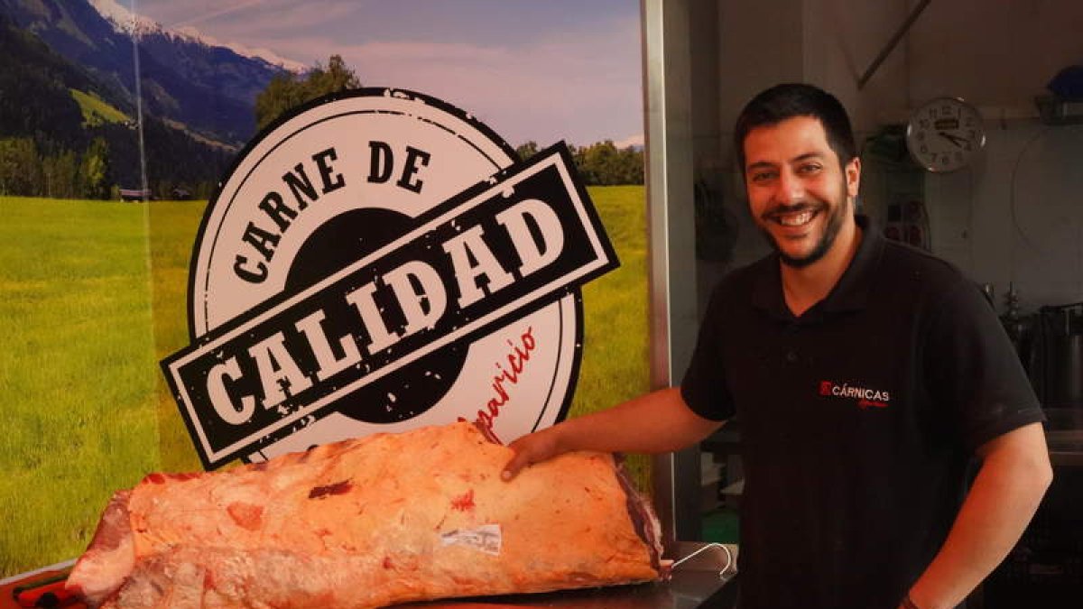 Pablo Aparicio posa con una pieza de carne en su carnicería en Veguellina de Órbigo. J. NOTARIO