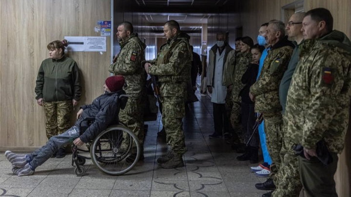 Miembros del ejército ucraniano, civiles y médicos asisten a una liturgia dirigida por un capellán ucraniano y médico de combate dentro de un hospital en Brovary, ROMAN PILIPEY