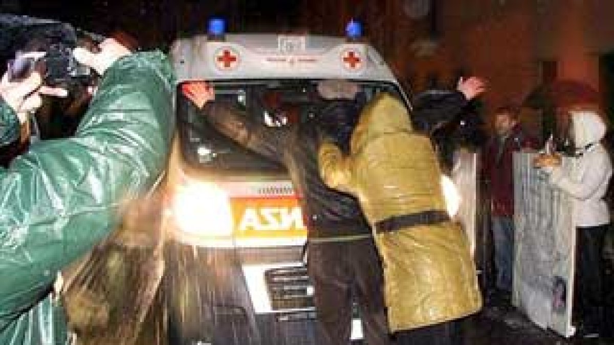 Varias personas intentando impedir el traslado en ambulancia de Eluana Englaro.