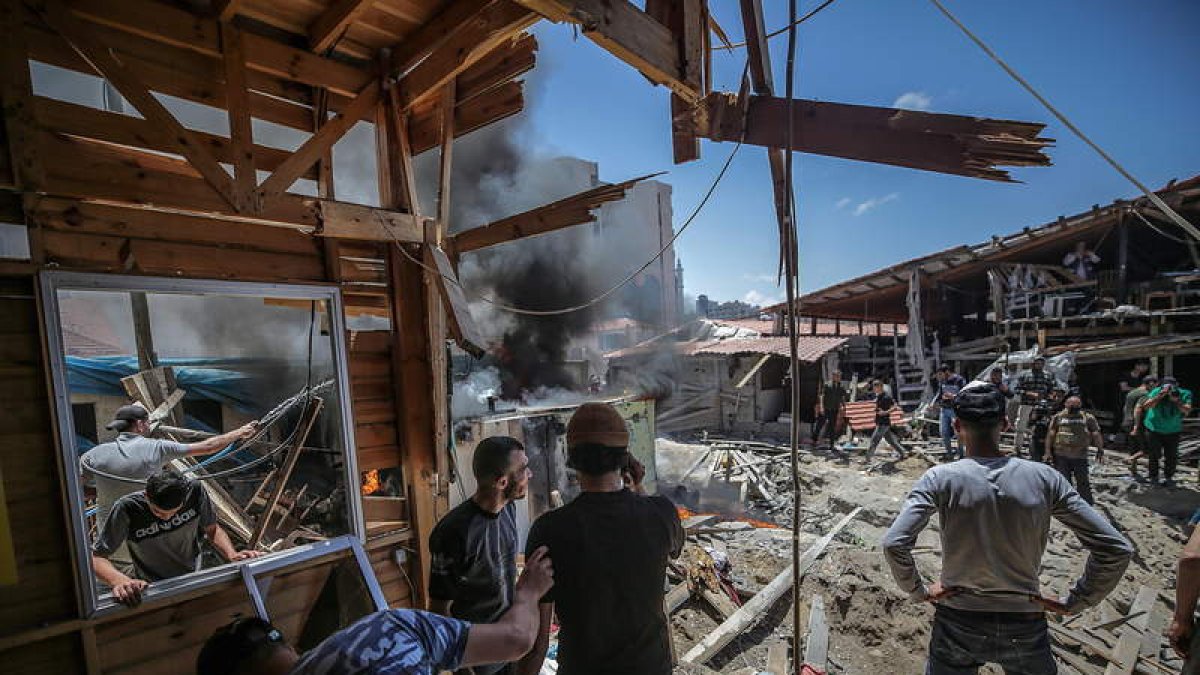 Los palestinos inspeccionan sus negocios tras la devastación del bombardero israelí. MOHAMMED SABER