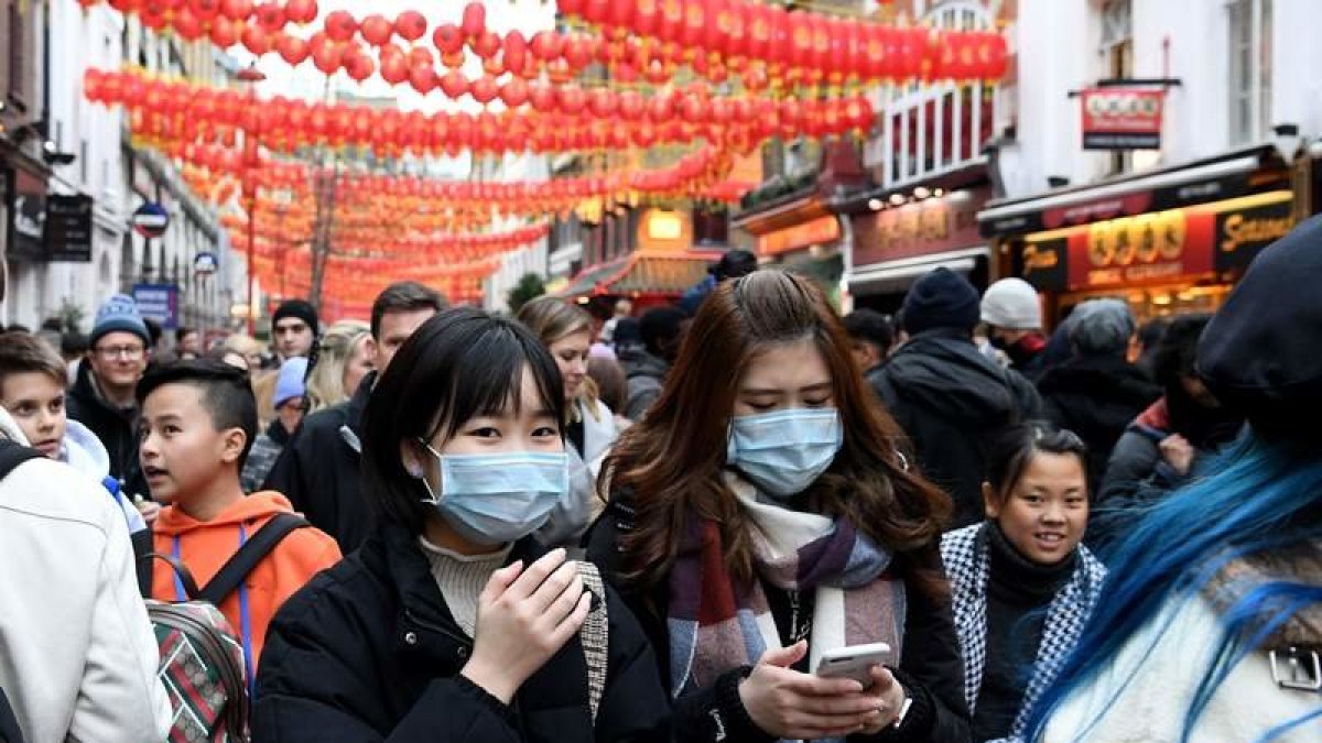 Peatones con máscaras en la fiesta del Año Nuevo Chino en Chinatown en Londres.