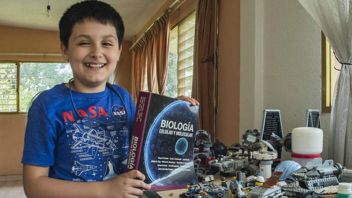 Carlos Antonio, con un libro de biología y sus construcciones de Lego /