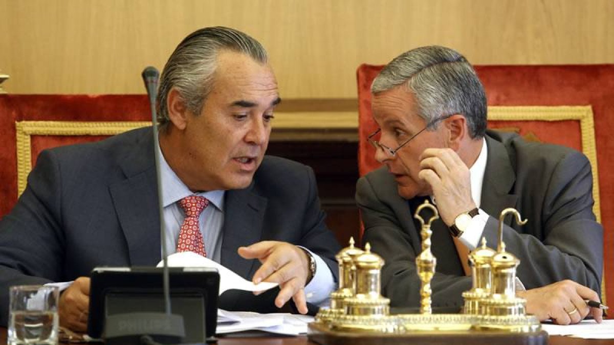El alcalde de León, Emilio Gutiérrez, conversa con el concejal de Hacienda, Agustín Rajoy, durante el pleno municipal de los Presupuestos 2014.