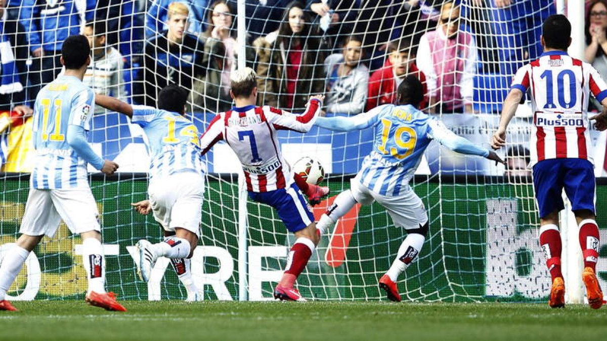 Antoine Griezmann marca un gol ante el defensa marfileño del Málaga Arthur Boka.