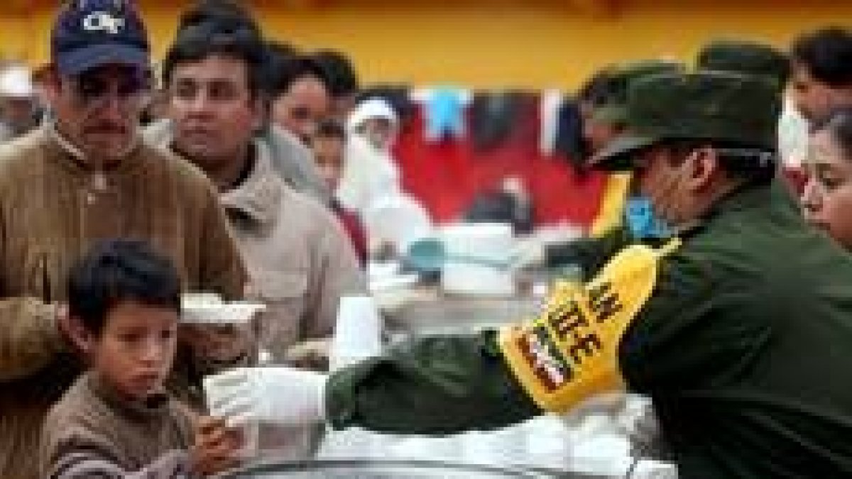 Decenas de mexicanos reciben una ración de comida del Ejército