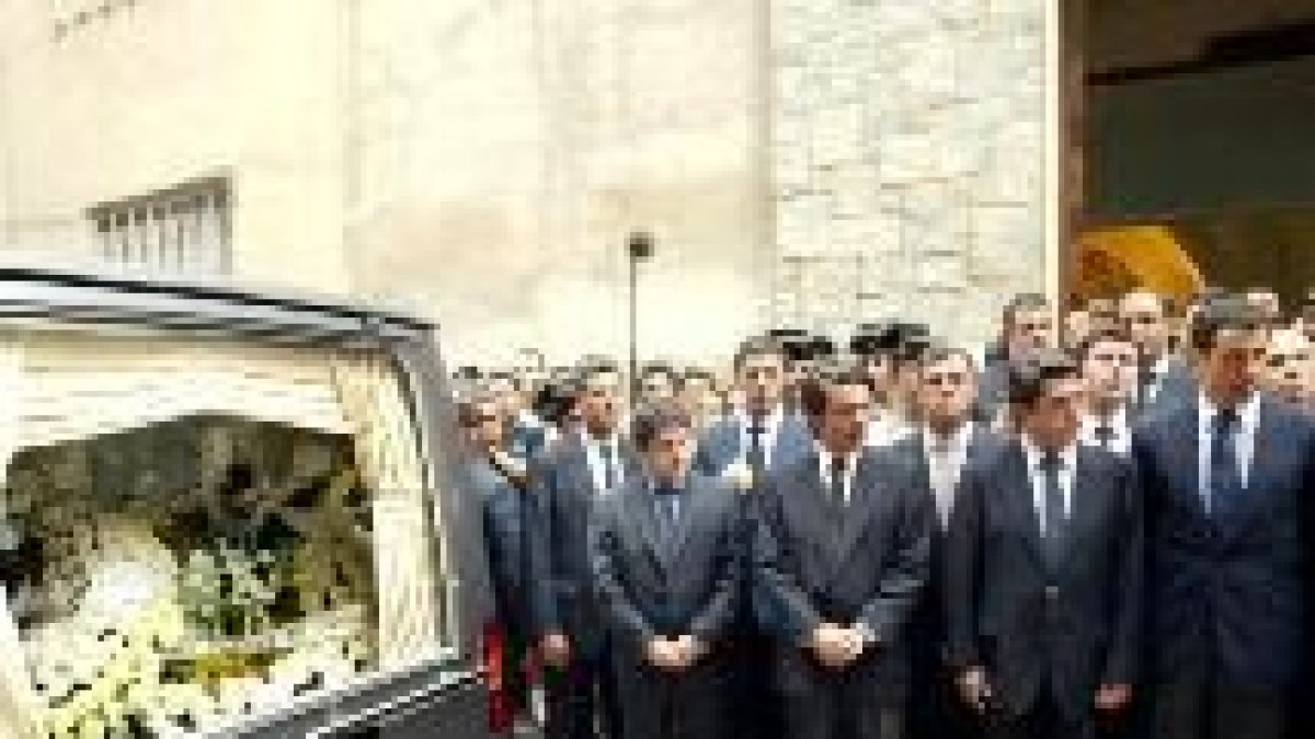En la imagen, los miembros del gobierno junto al coche fúnebre de los fallecidos en el atentado