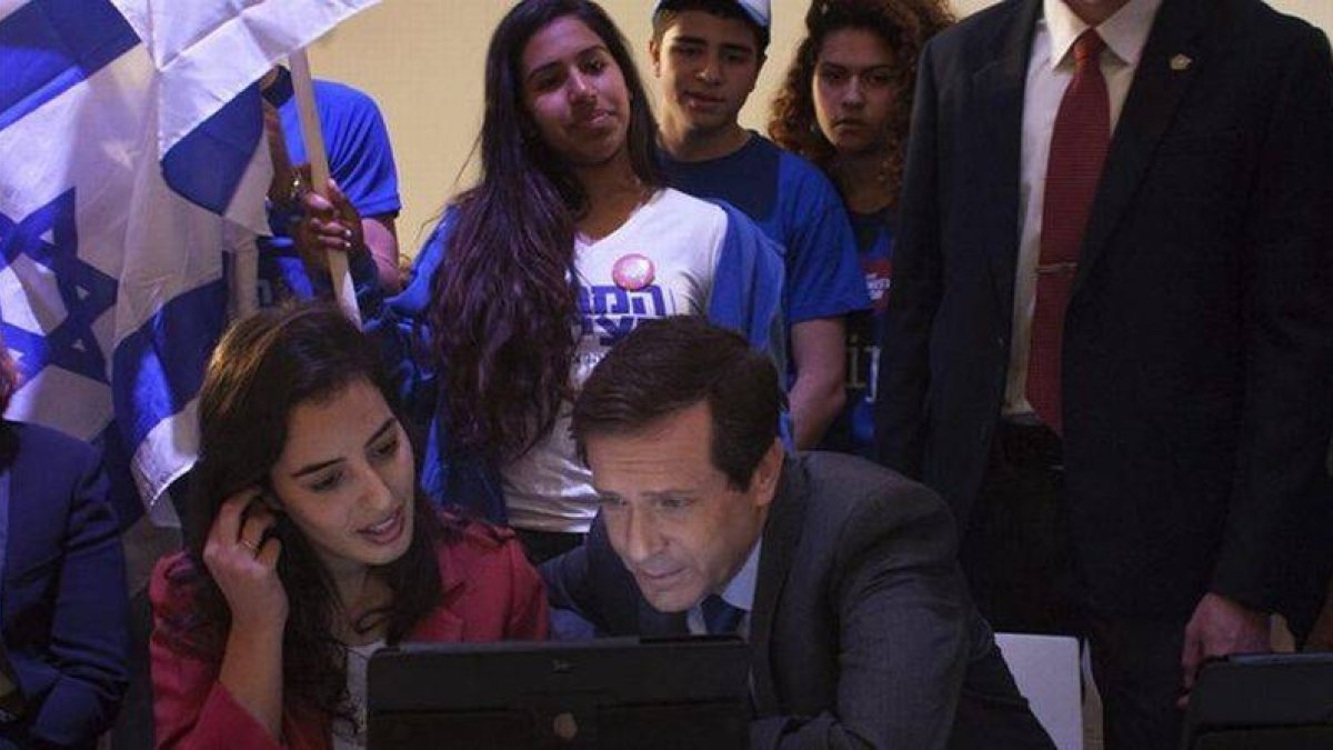 Herzog, líder de los laboristas, consulta datos en un ordenador junto a miembros del movimiento juvenil Dror, en una visita a colegios electorales en Tel-Aviv.