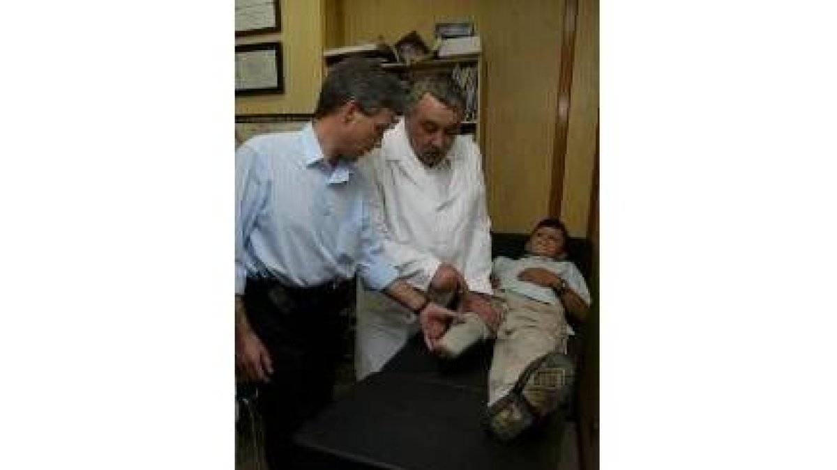 Un médico toma medidas para adaptar una prótesis a un niño