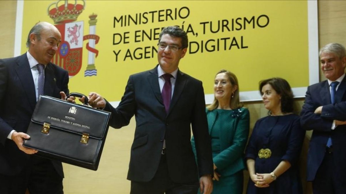 El ministro de Energía, Turismo y Agenda Digital, Álvaro Nadal, recibe la cartera ministerial de manos del titular de Economía, Luis de Guindos.