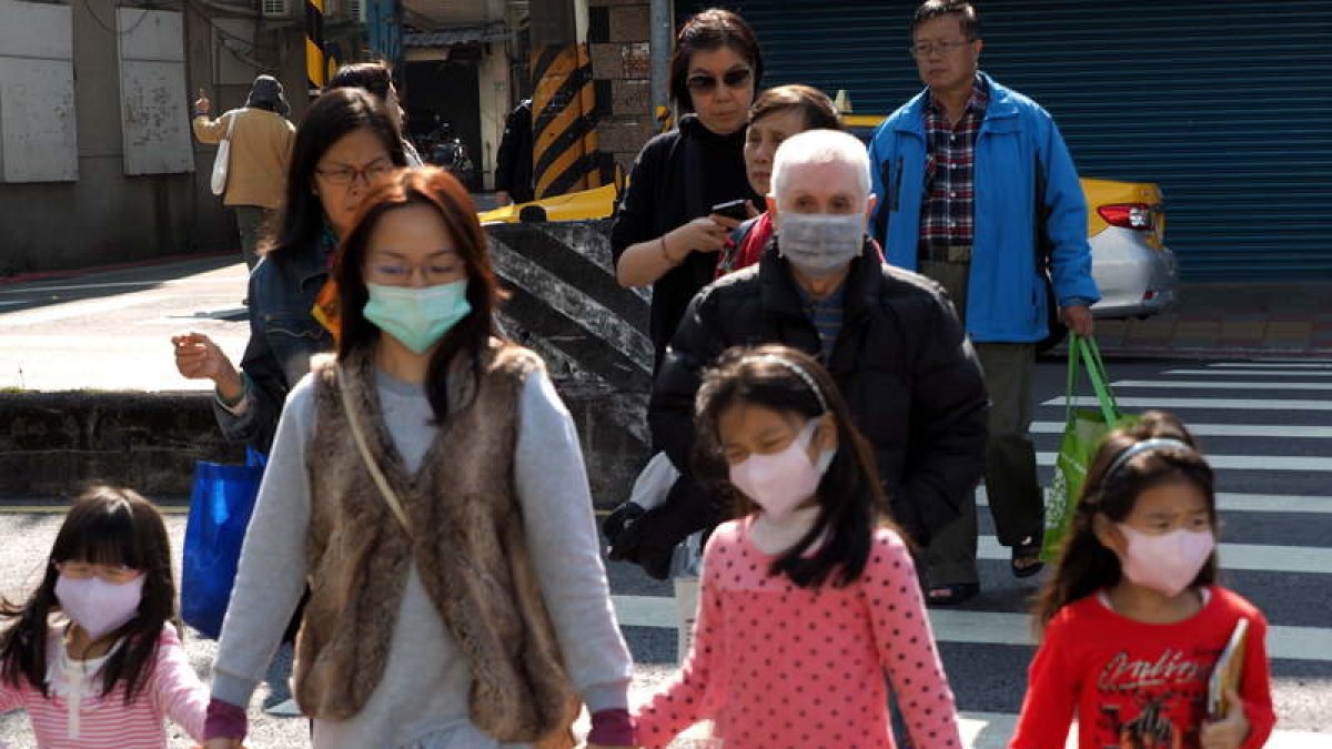 La población china se protege con mascarillas para evitar el contagio.