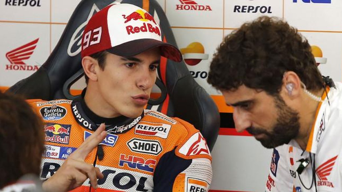 Marc Márquez conversa con un miembro de su equipo en el box de Repsol-Honda, en el circuito de Sepang.