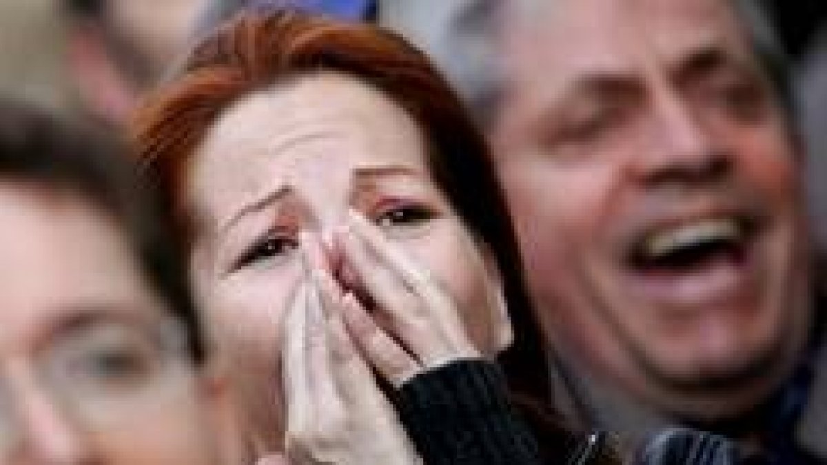 Una mujer escucha los porcentajes del escrutinio, ante la sede de la coalición del centro-izquierda