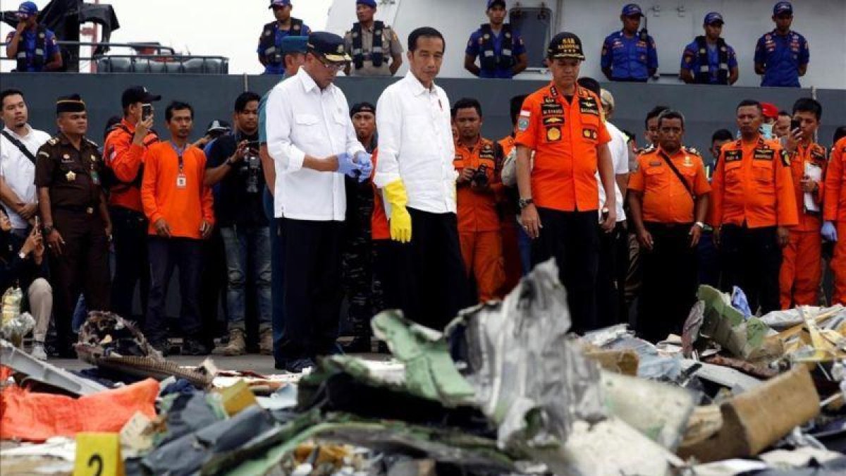 El presidente indonesio, Joko Widodo (centro), inspecciona algunos de los restos del avión de Lion Air siniestrado.