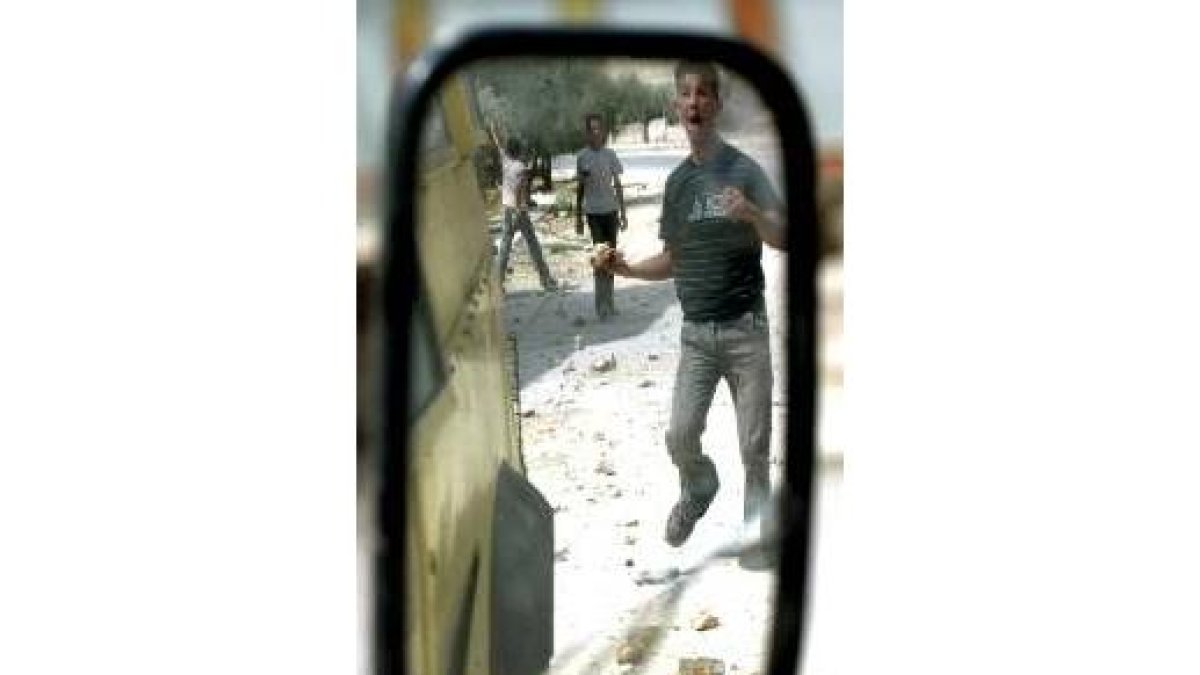 Un espejo retrovisor refleja a jóvenes palestinos de la Intifada