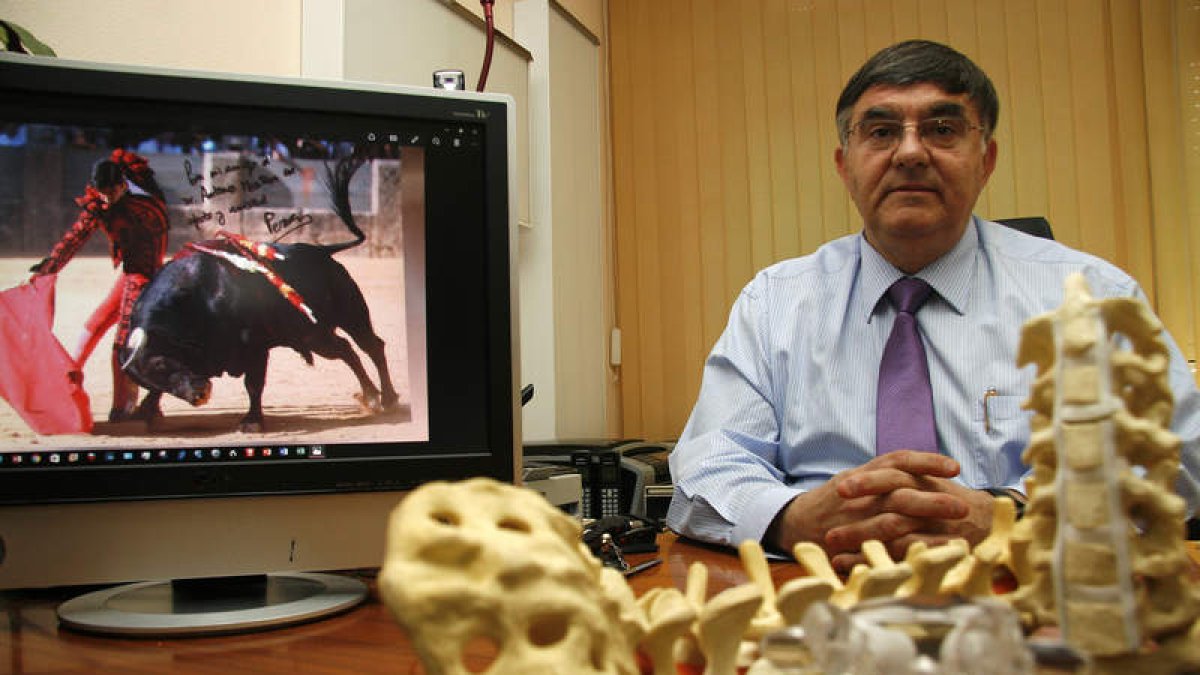 El neurocirujano Antonio Mostaza posa en su consulta con una fotografía dedicada de Miguel Ángel Pereda, paciente suyo en León. F. OTERO PERANDONES