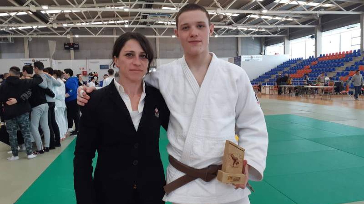 Pablo Fernández posa con el trofeo junto a su entrenadora Sara Terán.