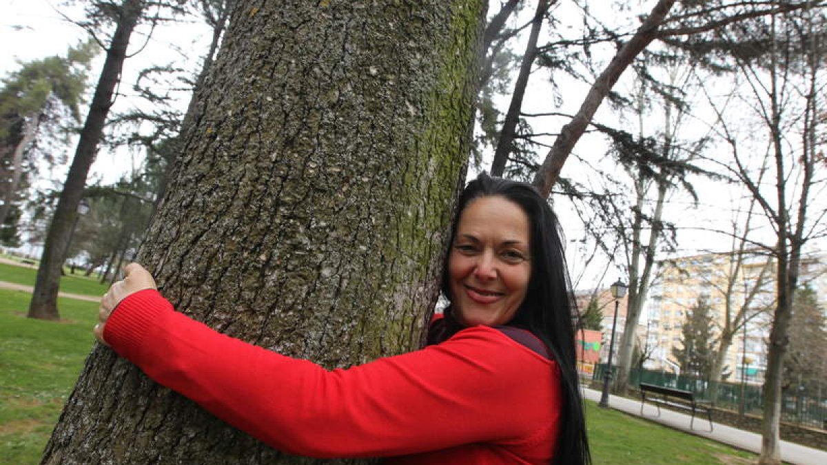 Mª Cruz García Rodera abraza a un árbol en El Plantío de Ponferrada: «La risa es la medicina más potente que tiene el ser humano».