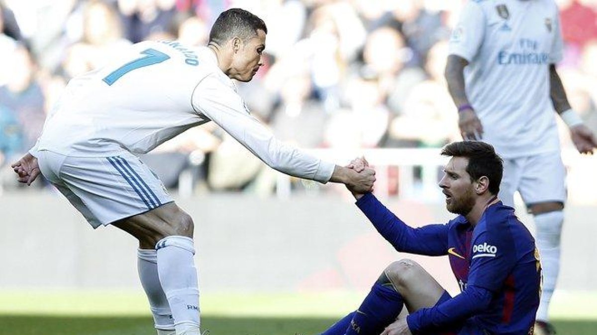 Cristiano ayuda a Messi a levantarse tras una falta que le cometieron en un clásico jugado en Madrid el 2017.