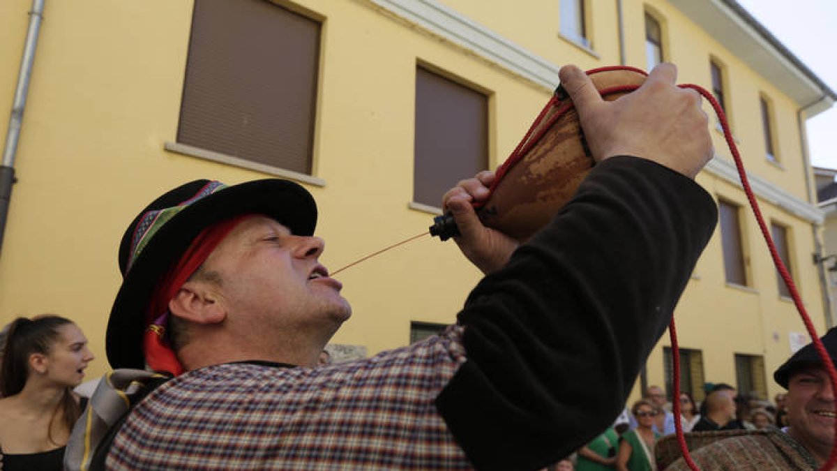 Un hombre bebe de una bota de vino durante l desfile de carros de San Froilán. FERNANDO OTERO PERANDONES