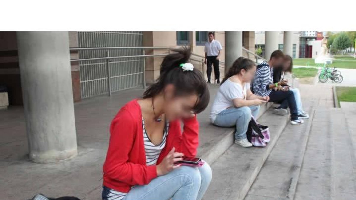 Estudiantes utilizando sus teléfonos móviles en la Universidad de León.